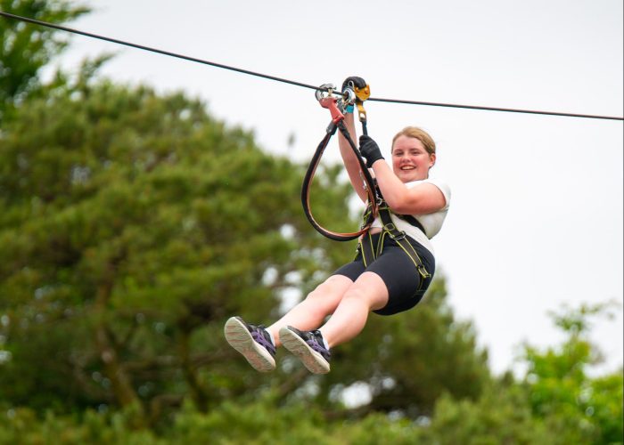 Enjoy a thrilling day at Zipit, soaring through the lush forest canopy. Experience the excitement of ziplining while smiling in your harness and casual clothing. Plan this unforgettable Family Day Out during Summer 2024 for adventure and laughter together!